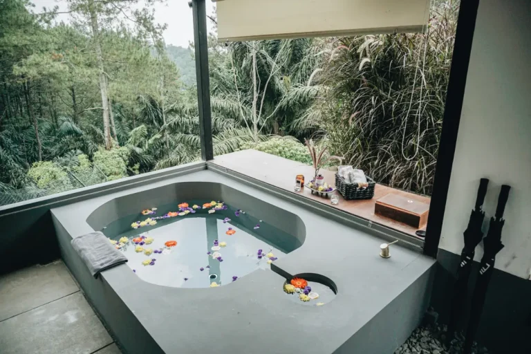 Bathtub outdoor dengan taburan bunga di balkon Solitude Cabin